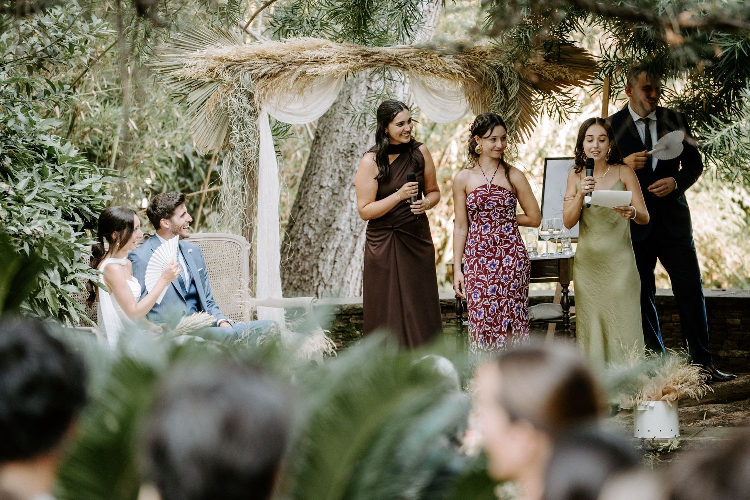 Outdoor wedding ceremony guests gathered in a natural garden setting.