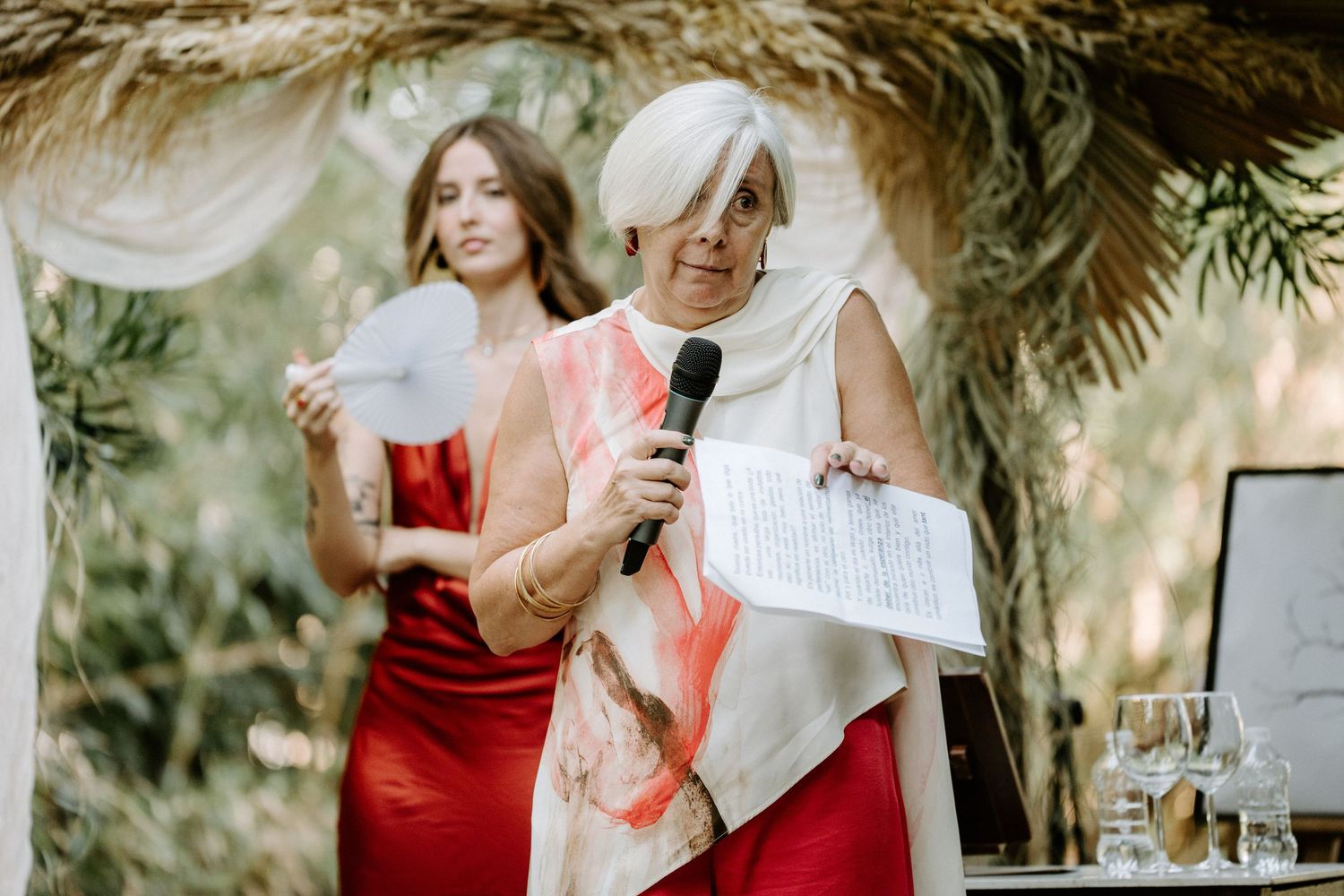 Wedding celebration in garden setting with red accents and natural decor.
