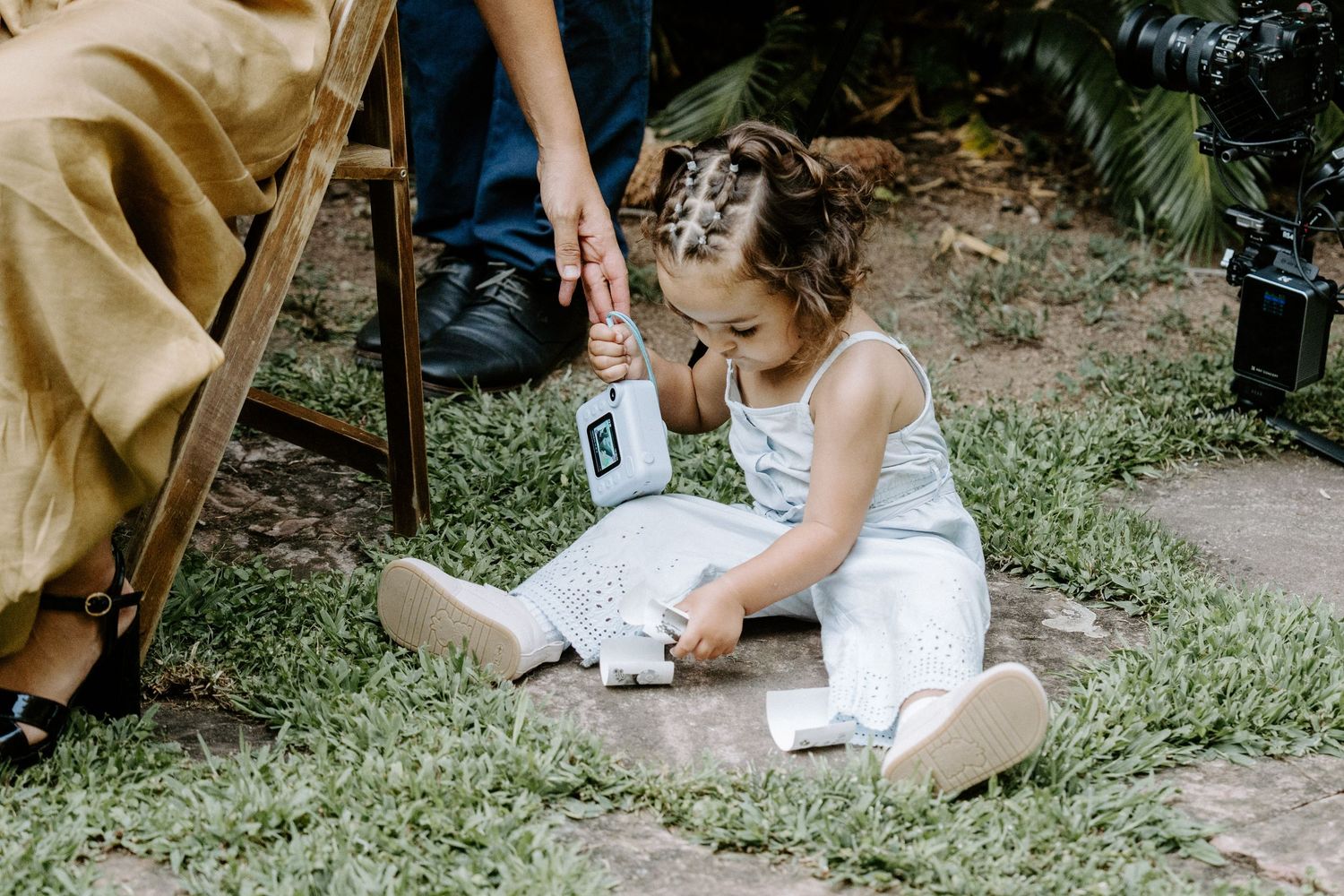 Candid moments captured during outdoor wedding ceremony on grassy lawn.
