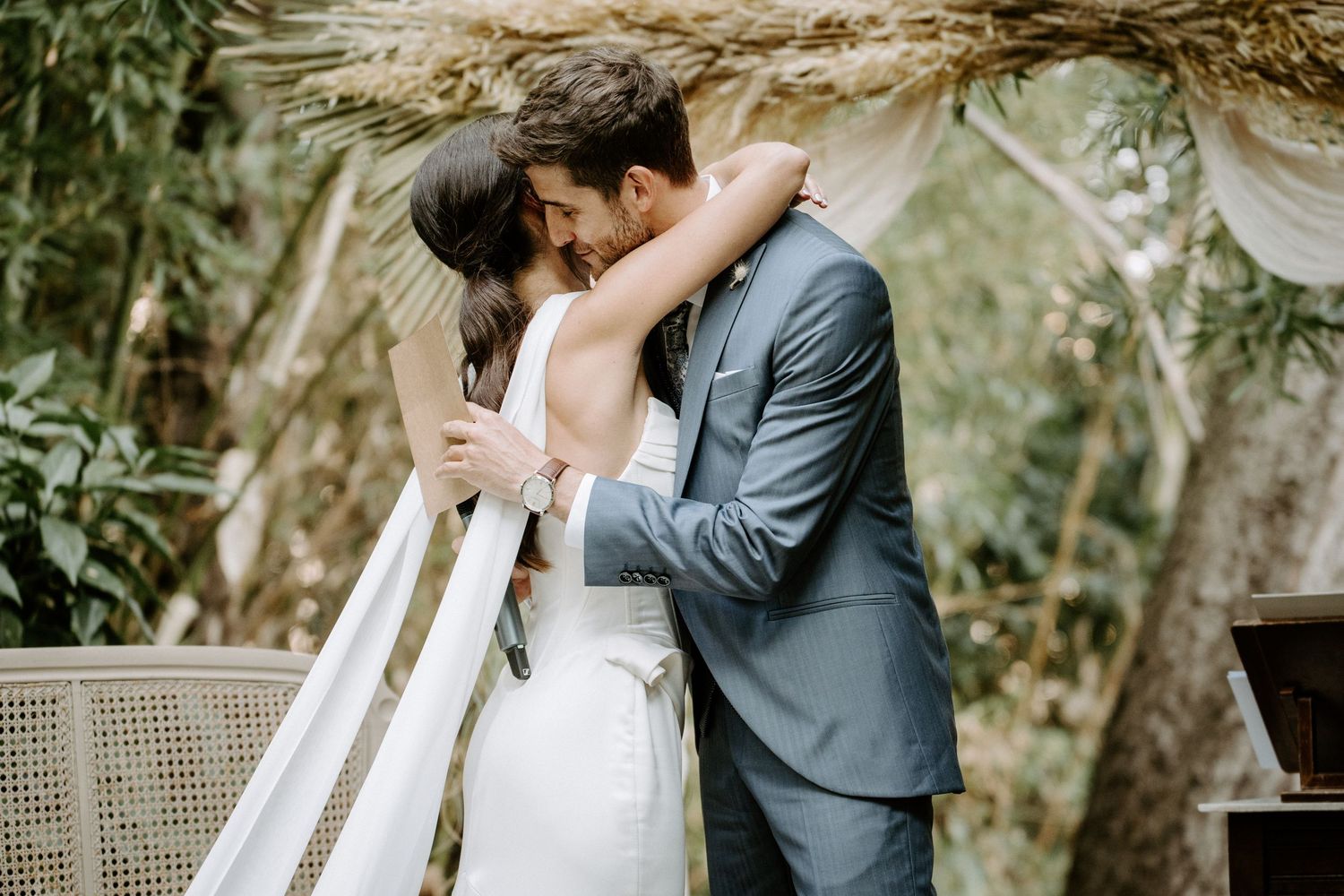 Elegant wedding ceremony setup with white chairs and floral arrangements in an outdoor garden.