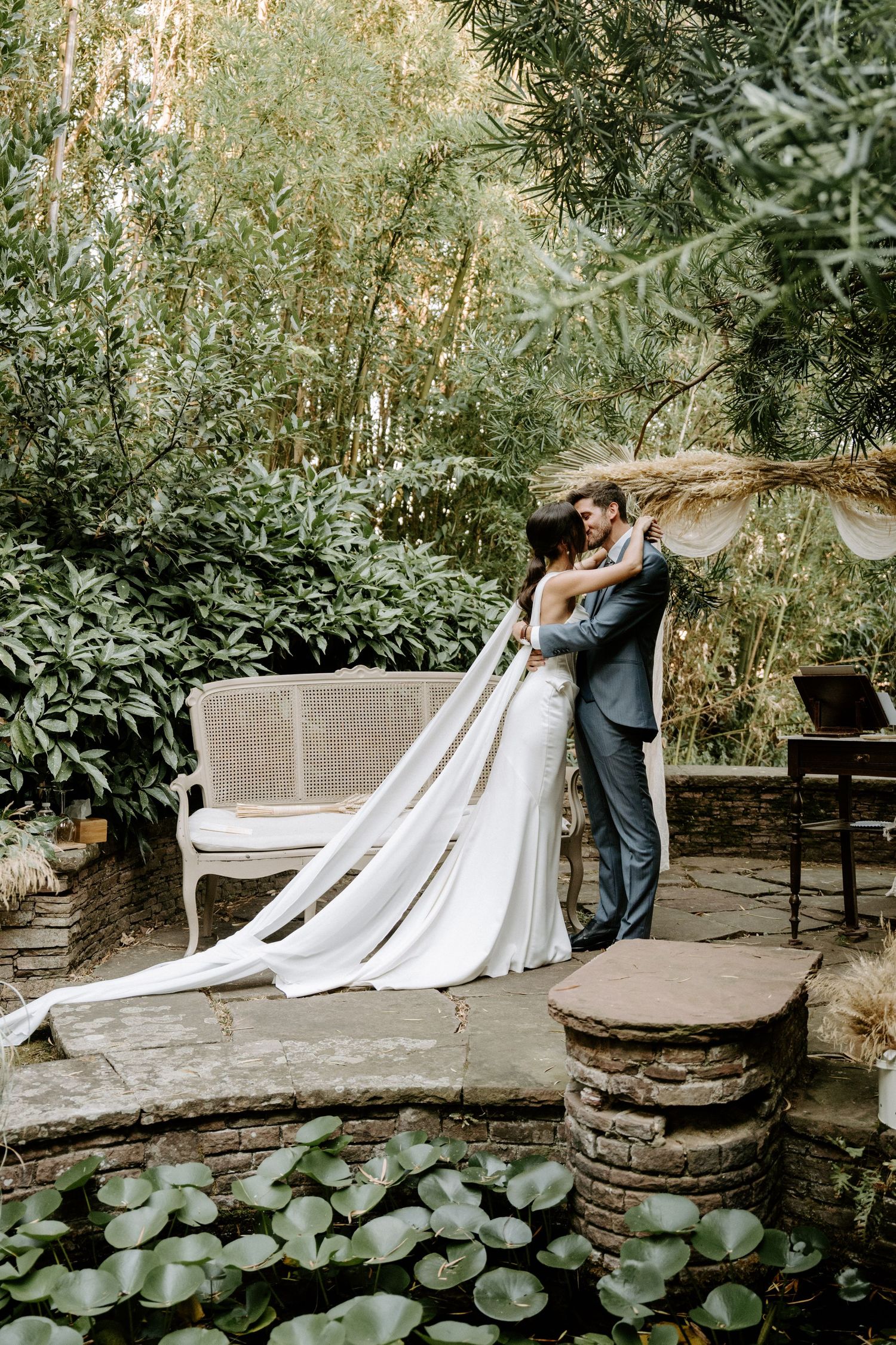 Beautiful garden wedding scene with lily pads and rustic benches creating a peaceful atmosphere.