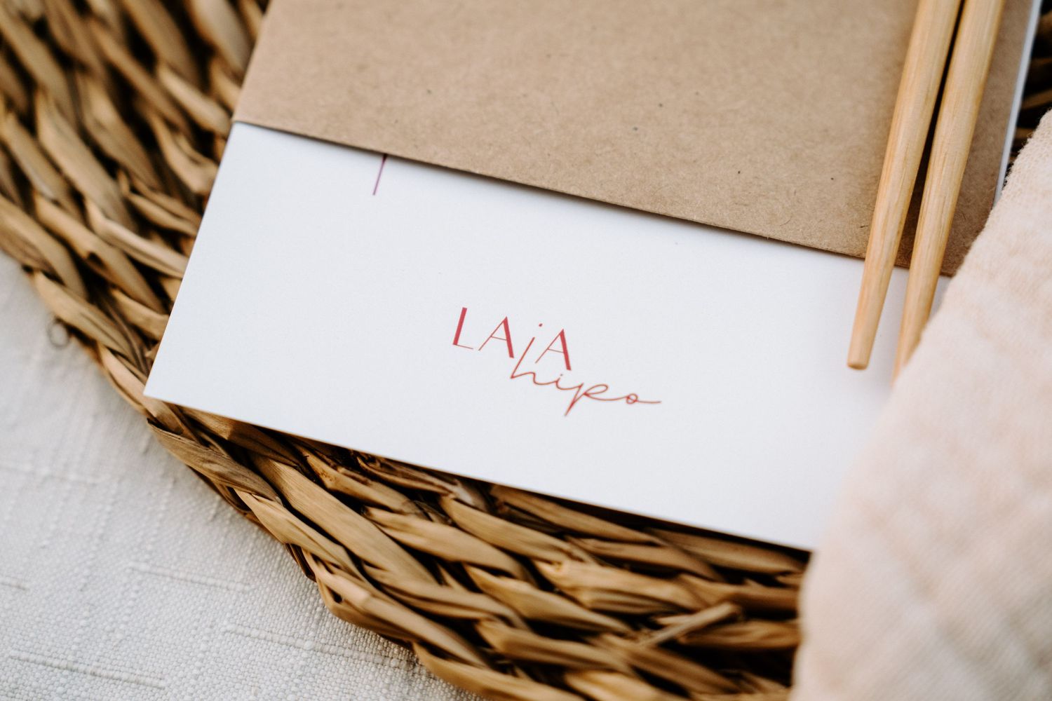 Place settings with wooden chopsticks and woven chargers on a natural textured surface.