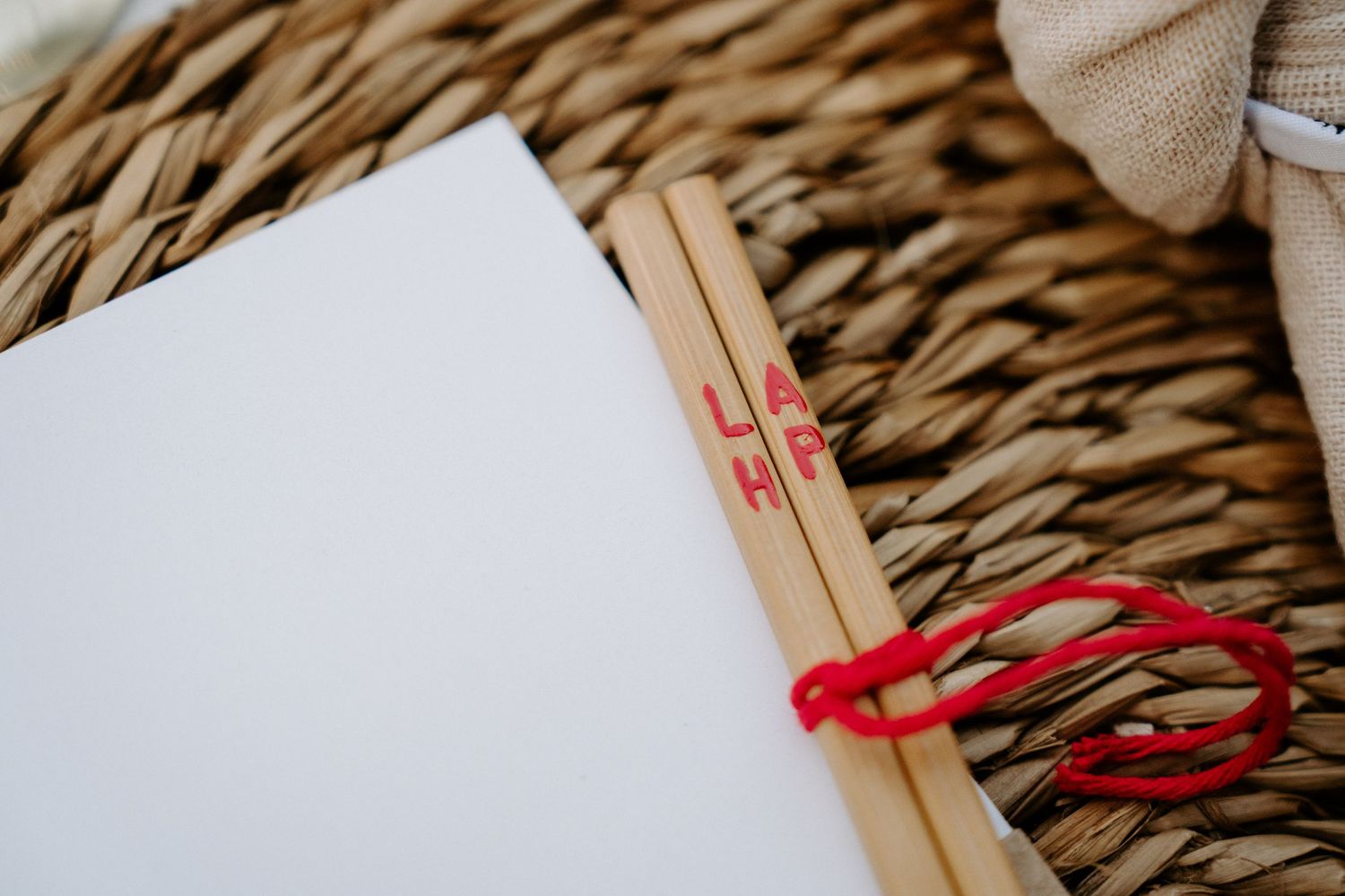 Minimalist table decor with chopsticks and red accents on woven placemats.