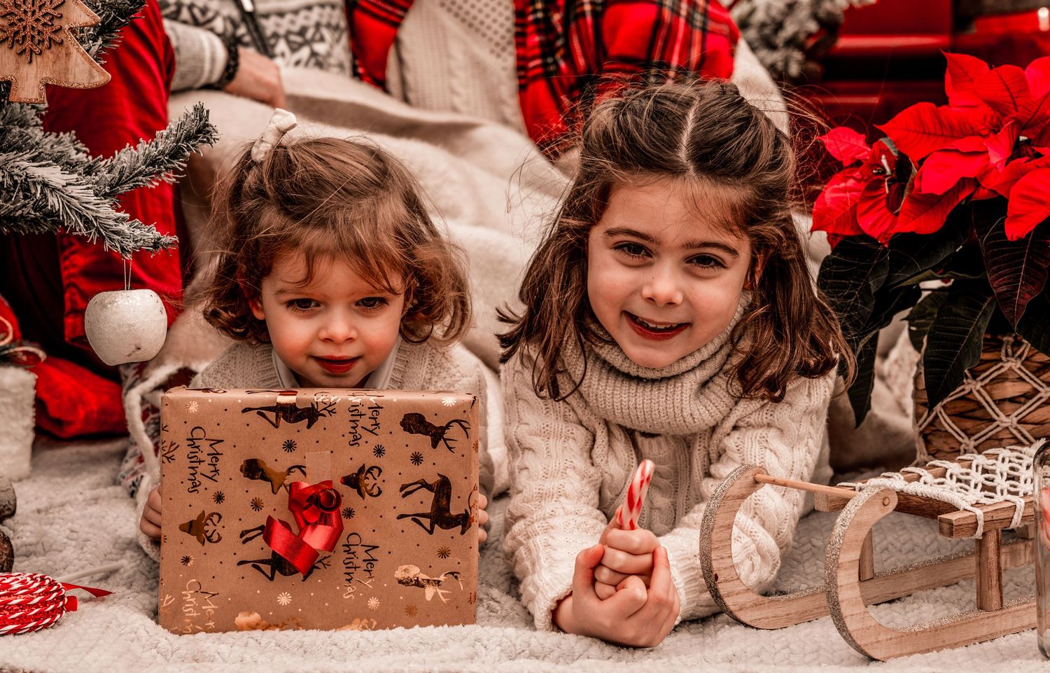Holiday decorations arranged with rustic wooden boxes, red plaid textiles, and festive ornaments in a cozy Christmas display.