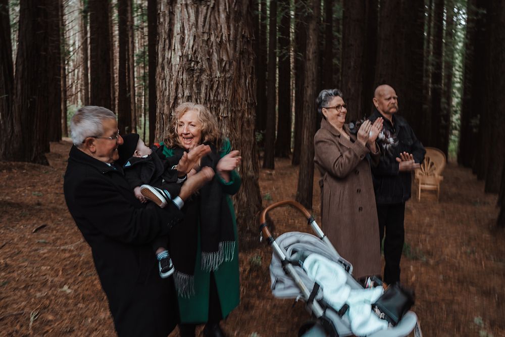 Couples dancing together in a beautiful redwood forest setting with golden light filtering through the trees.