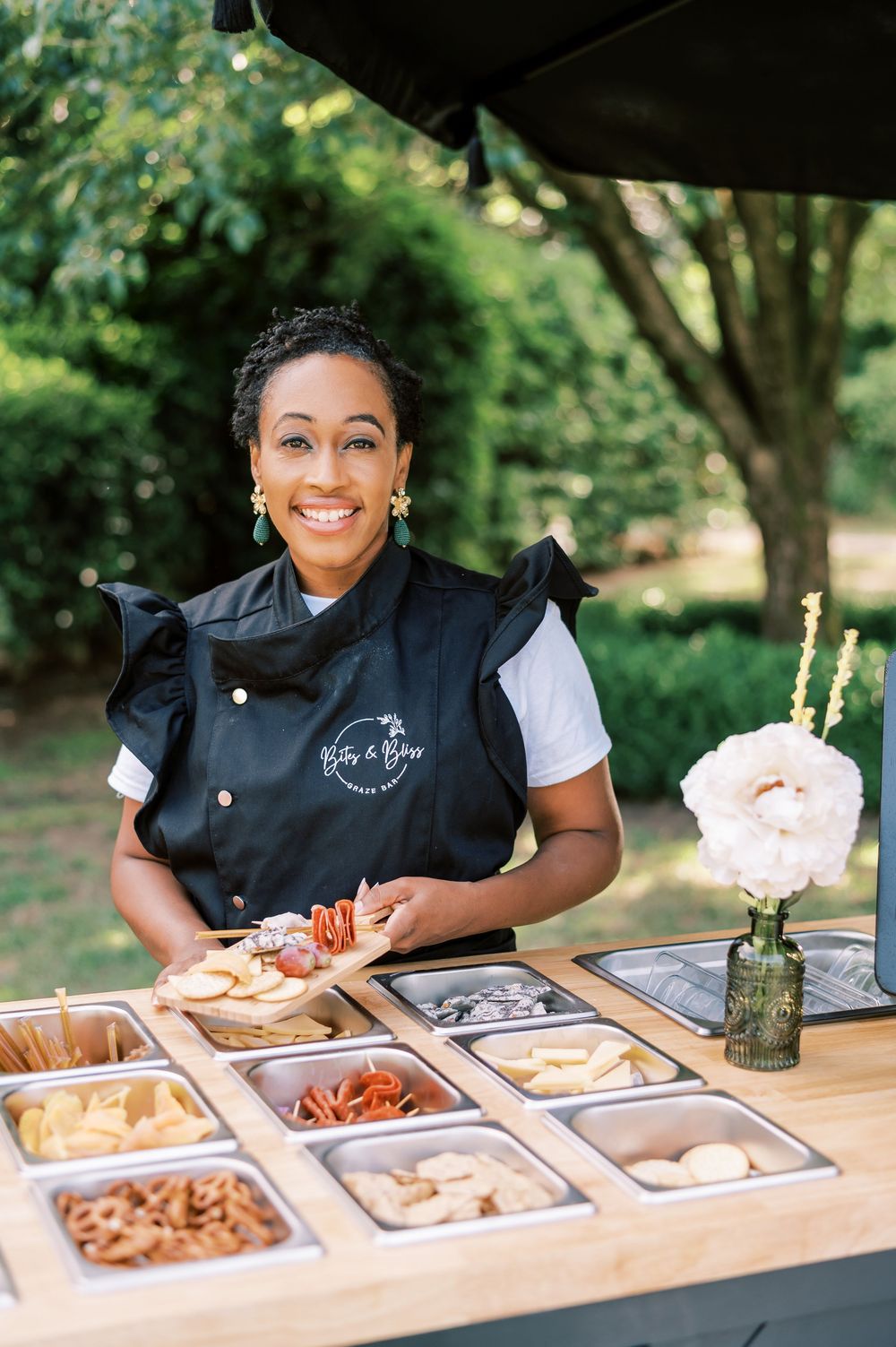 Bites and Bliss staff presents food display at outdoor buffet station, used for branding in Fayetteville NC