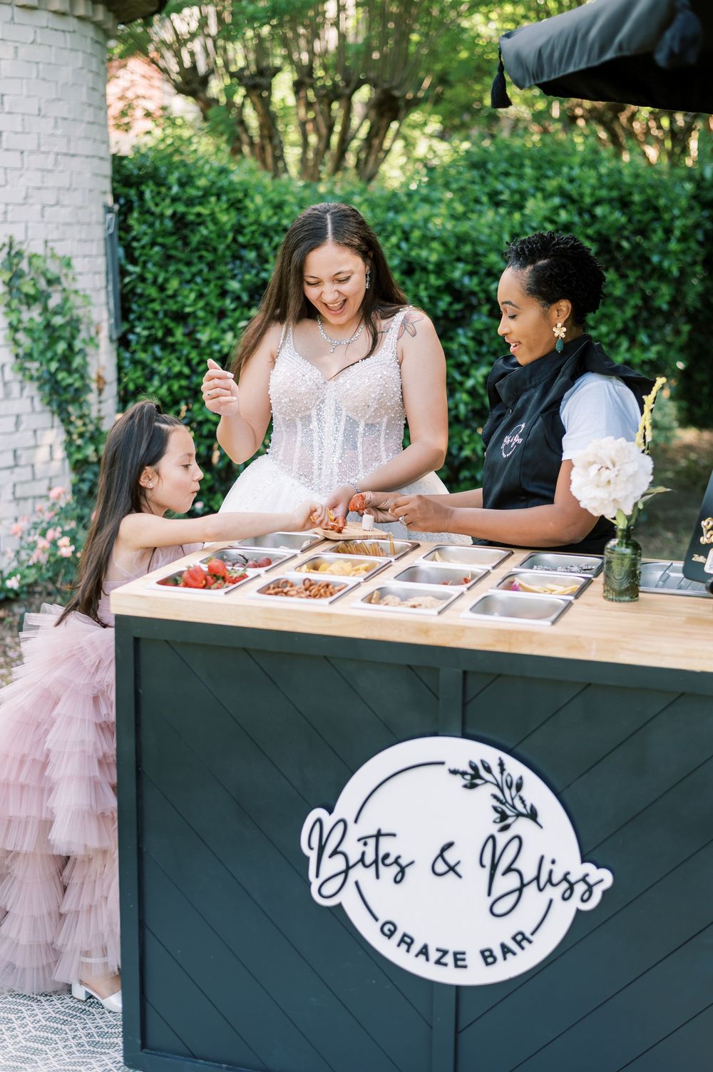 A mobile food service station labeled 'Graze Bar' serving food outdoors with people gathered around it during an event.