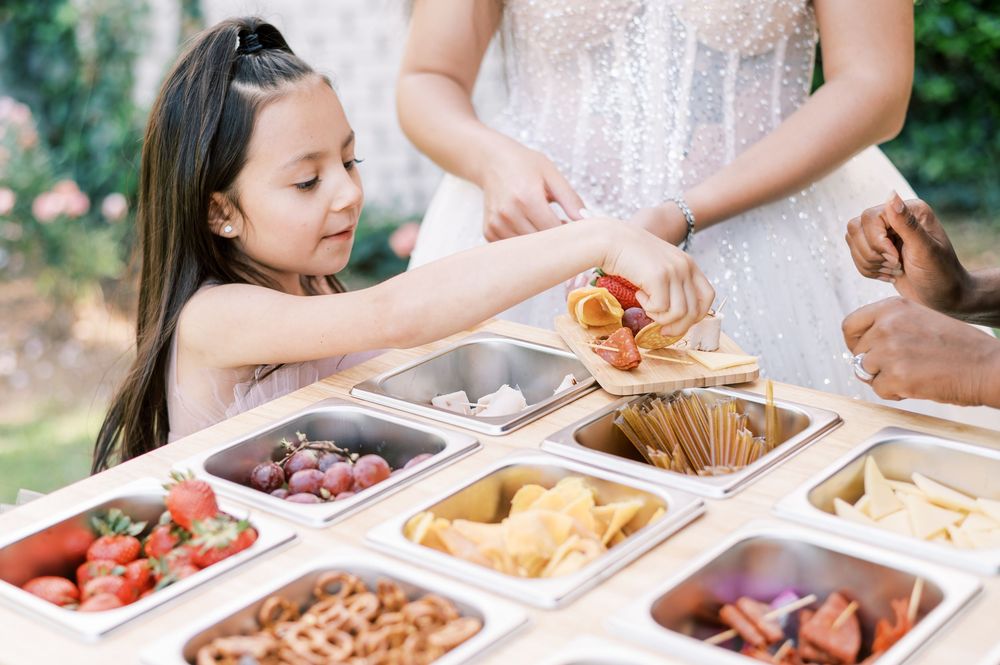 Little girl choosing yummy charcuterie options from a mobile graze bar in Fayetteville North Carolina