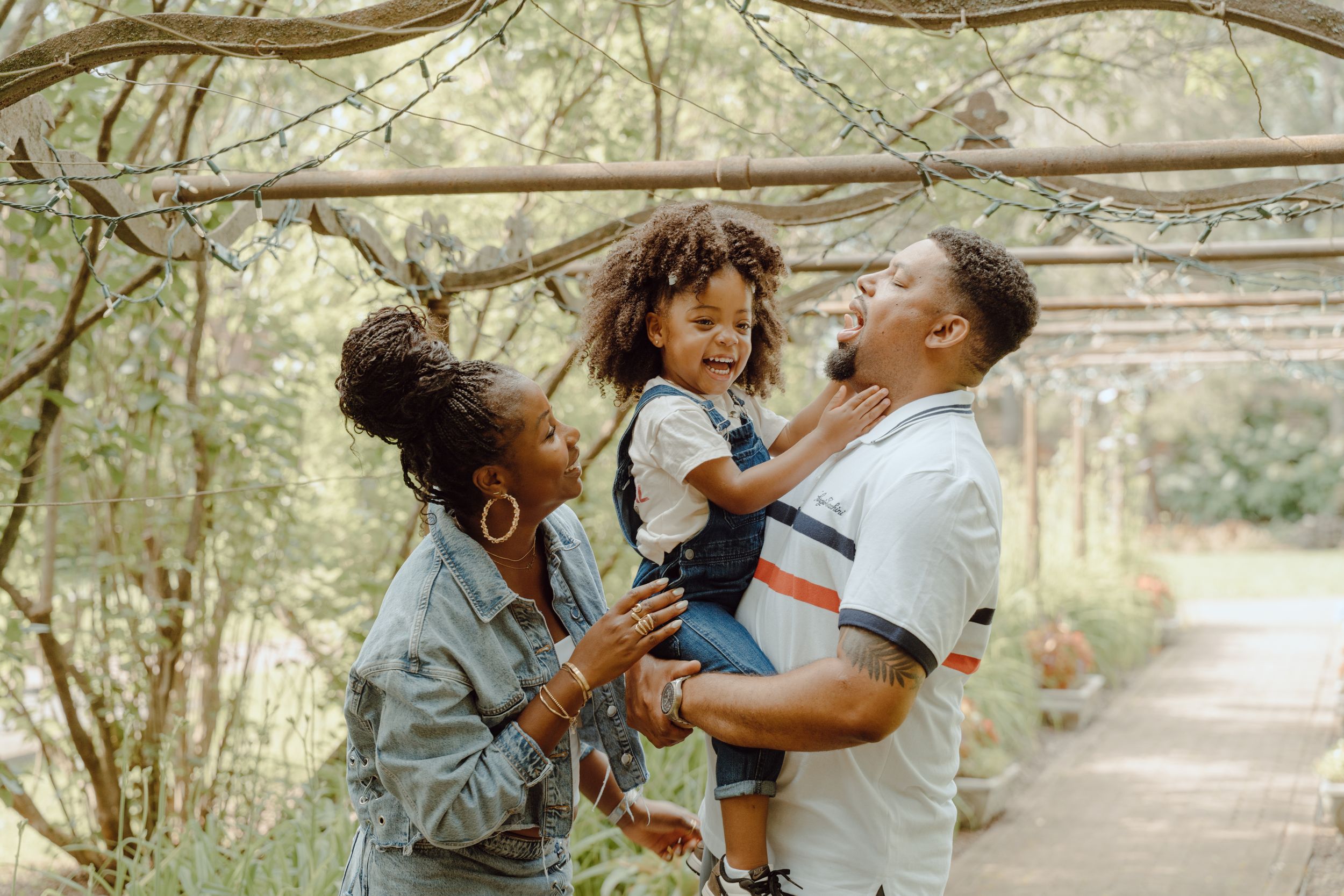 A joyful family moment of laughter and play in a natural garden setting.