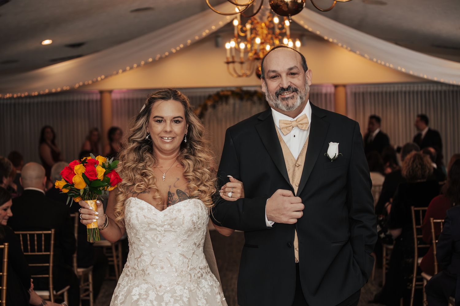 A celebratory moment at a wedding reception with decorative lighting and floral arrangements.