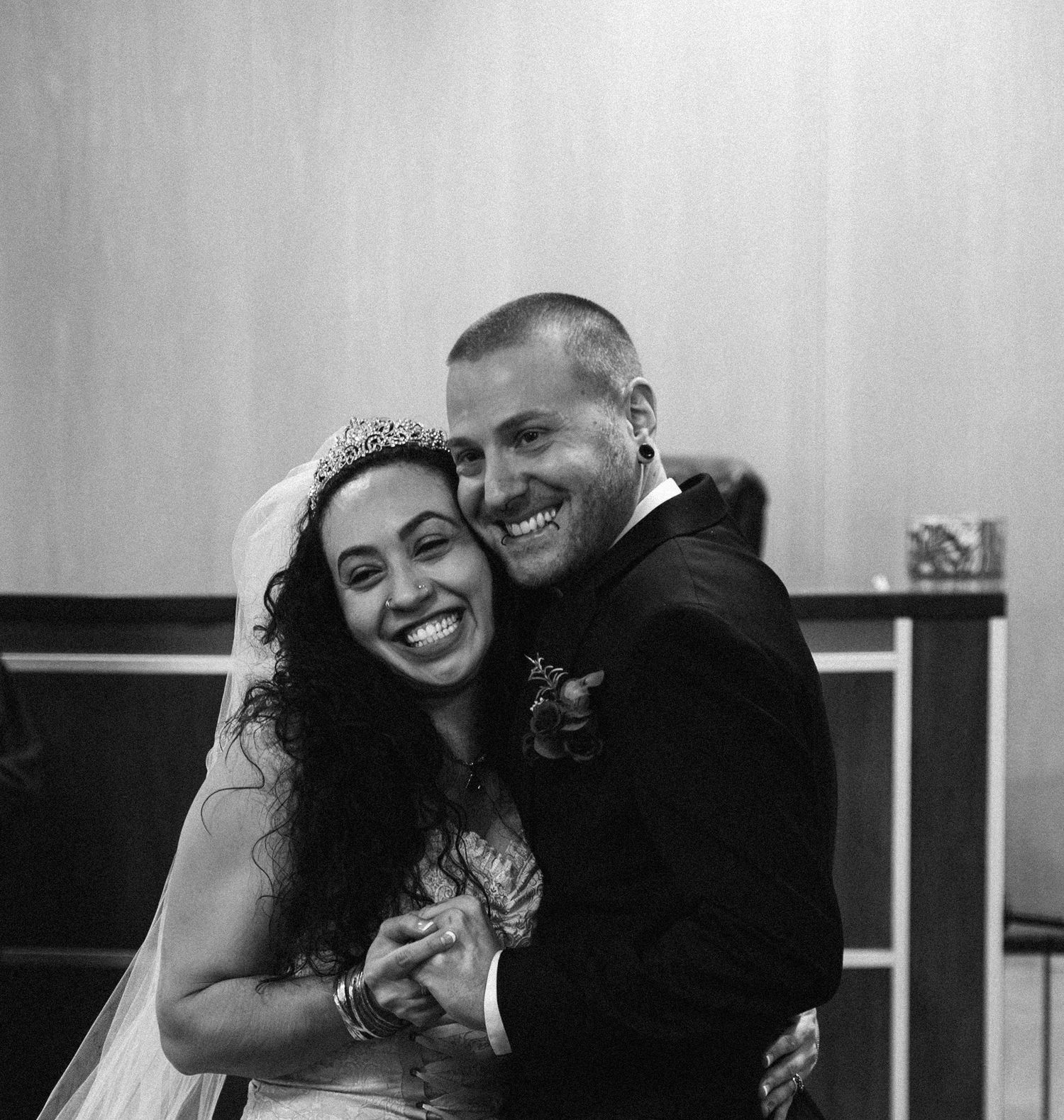 A joyful wedding portrait captured in black and white with natural expressions.