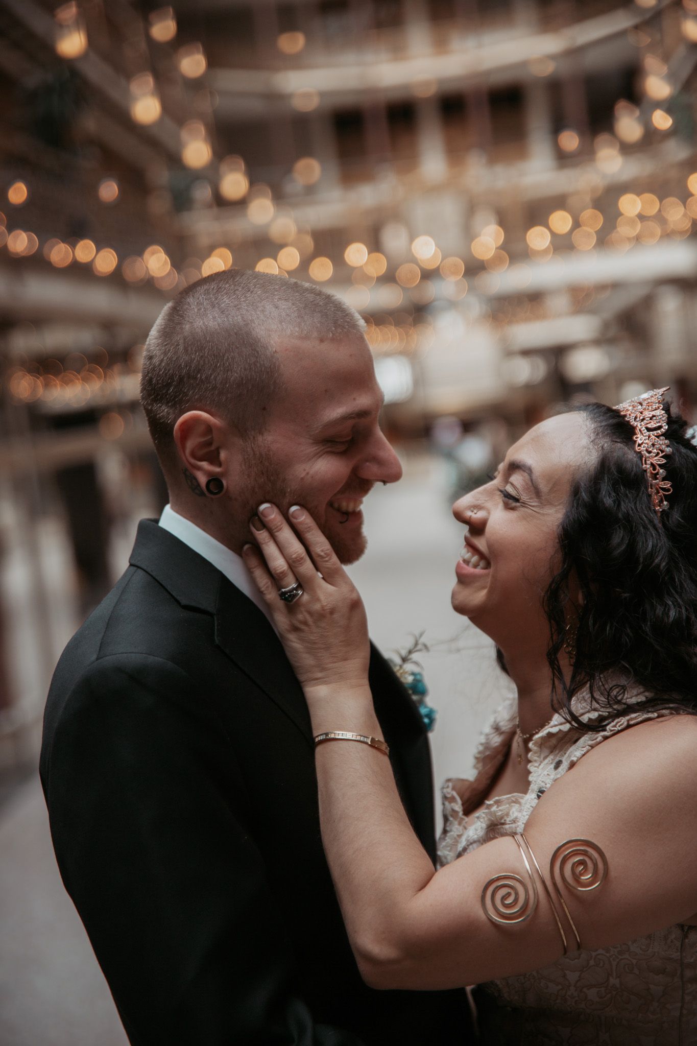 Joyful couple shares intimate romantic moments in a beautifully lit wedding setting.