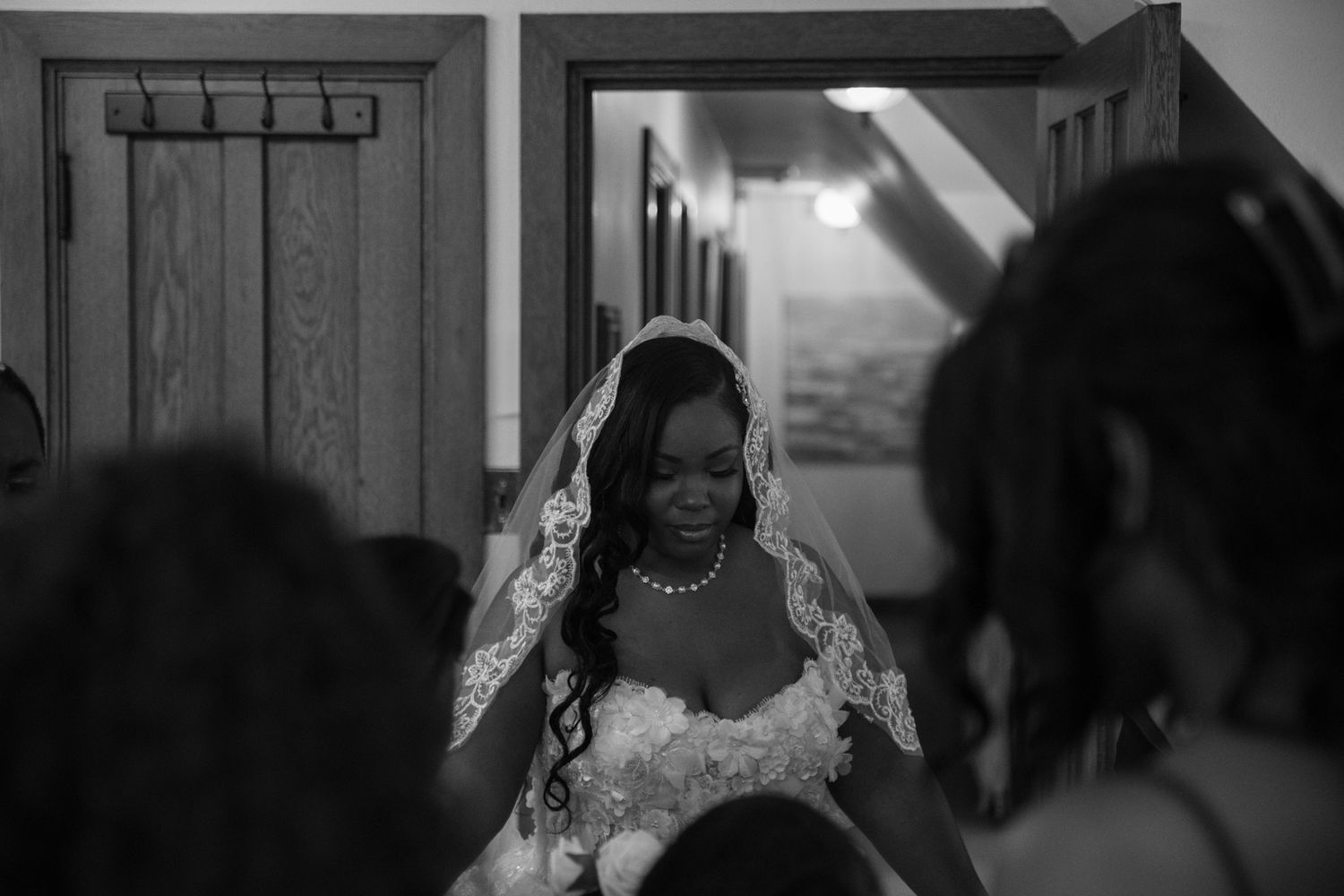 Black and white wedding photography with dramatic indoor lighting and shadows.