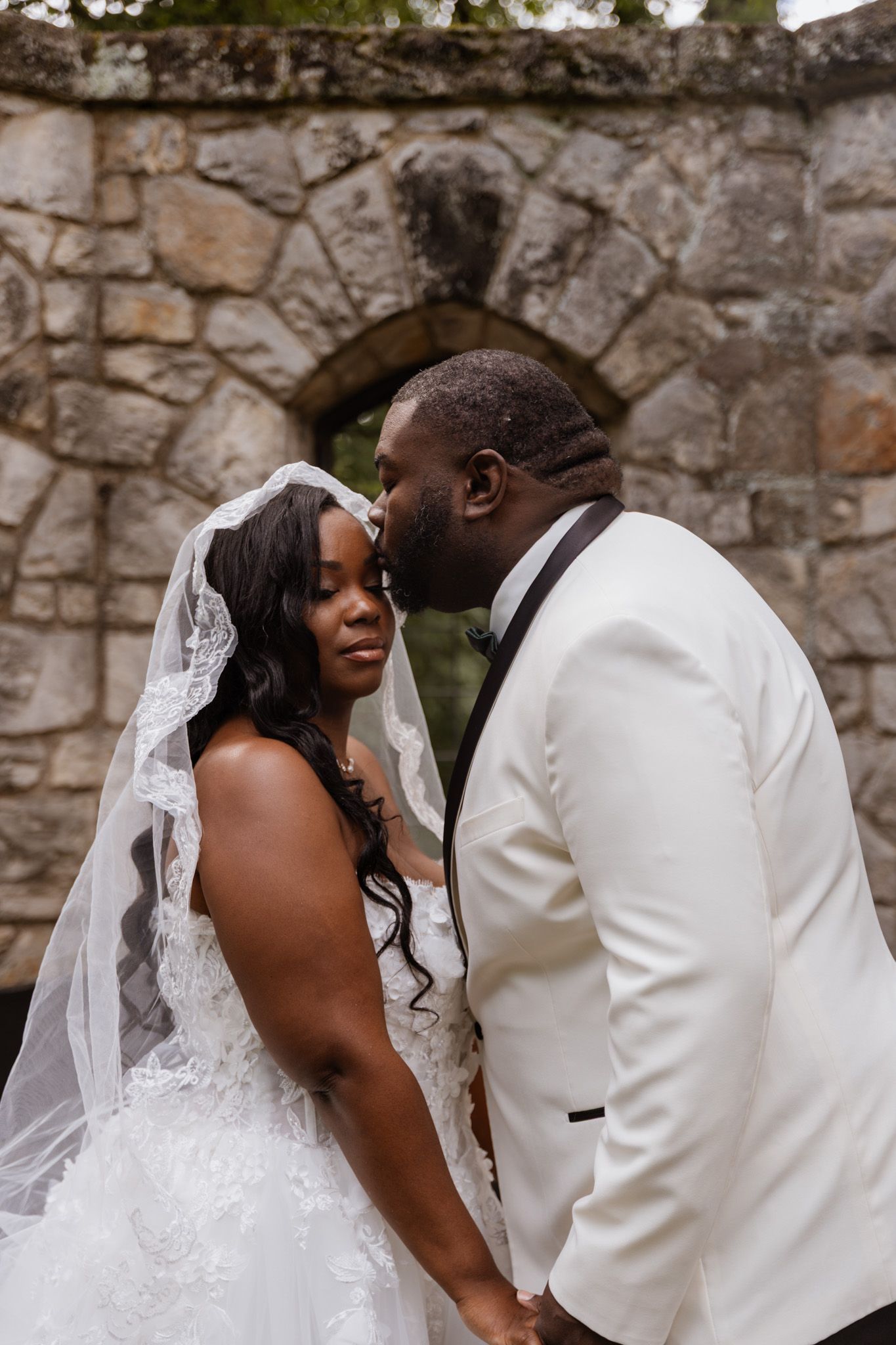A romantic wedding photoshoot sequence showing tender moments against a stone wall backdrop.