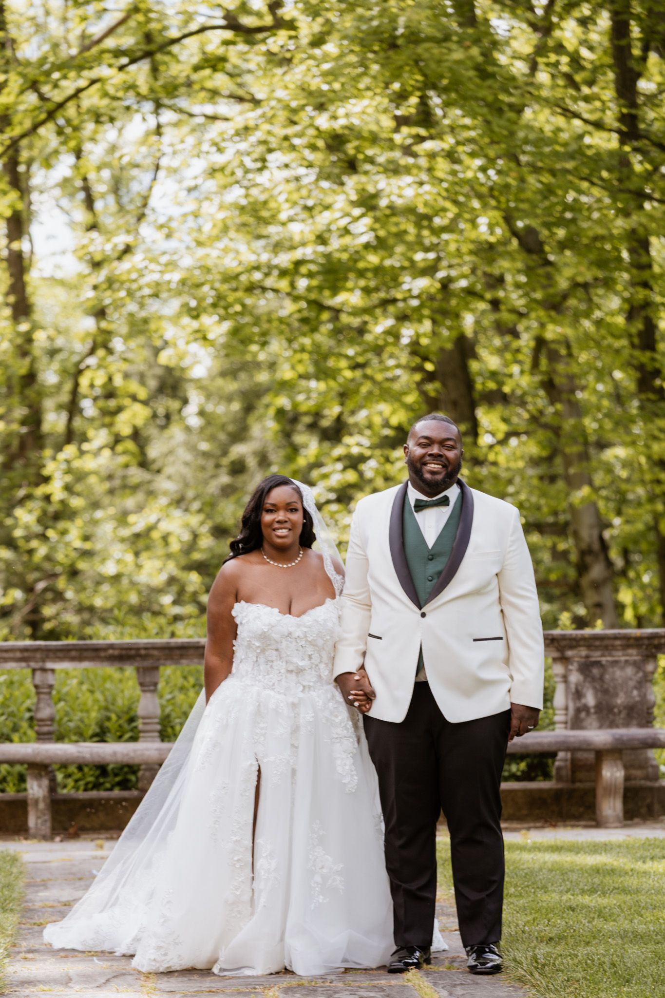 Wedding portraits taken outdoors with a lush green forest background.