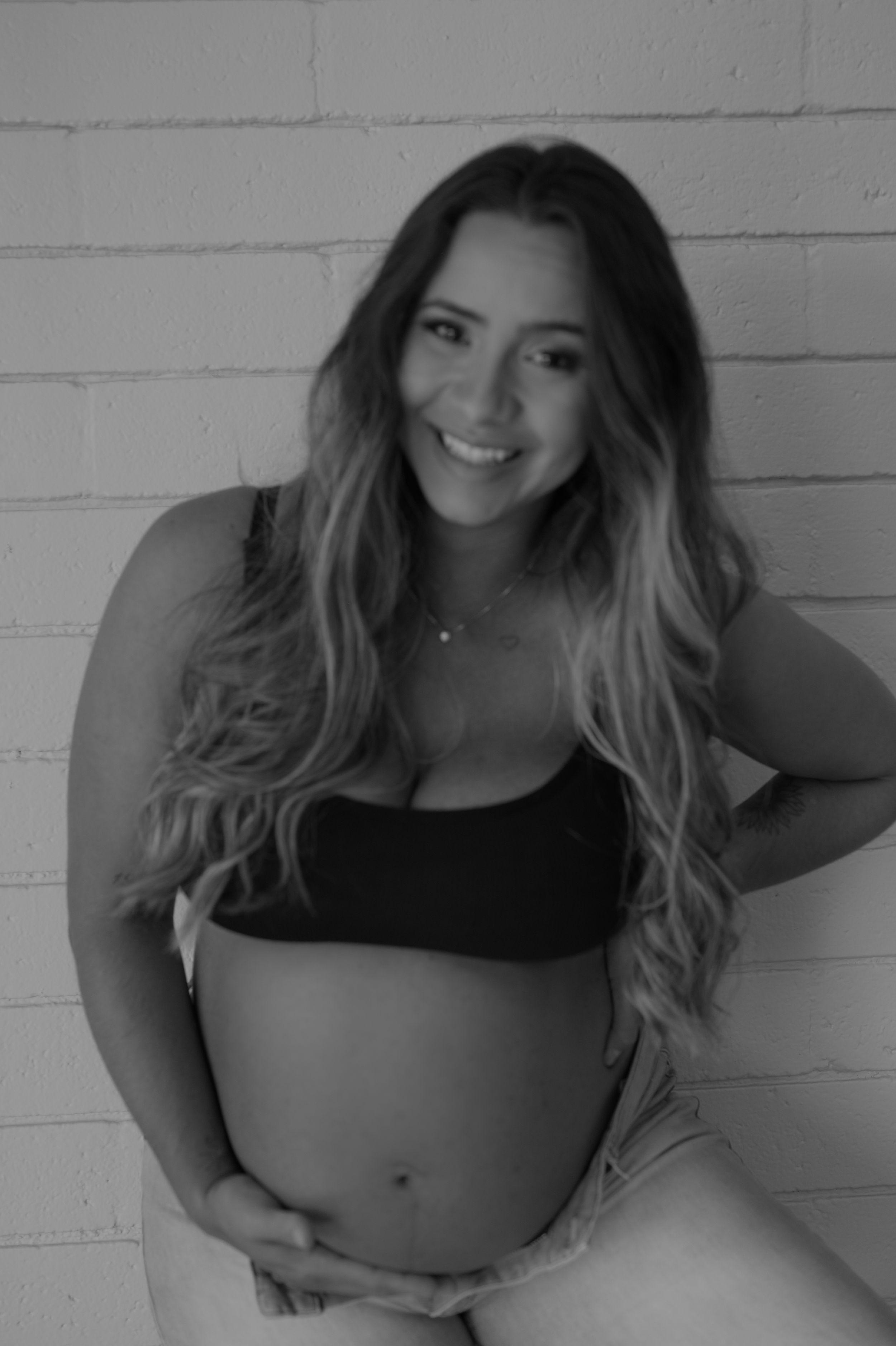 Black and white maternity portrait showcasing a glowing pregnancy.
