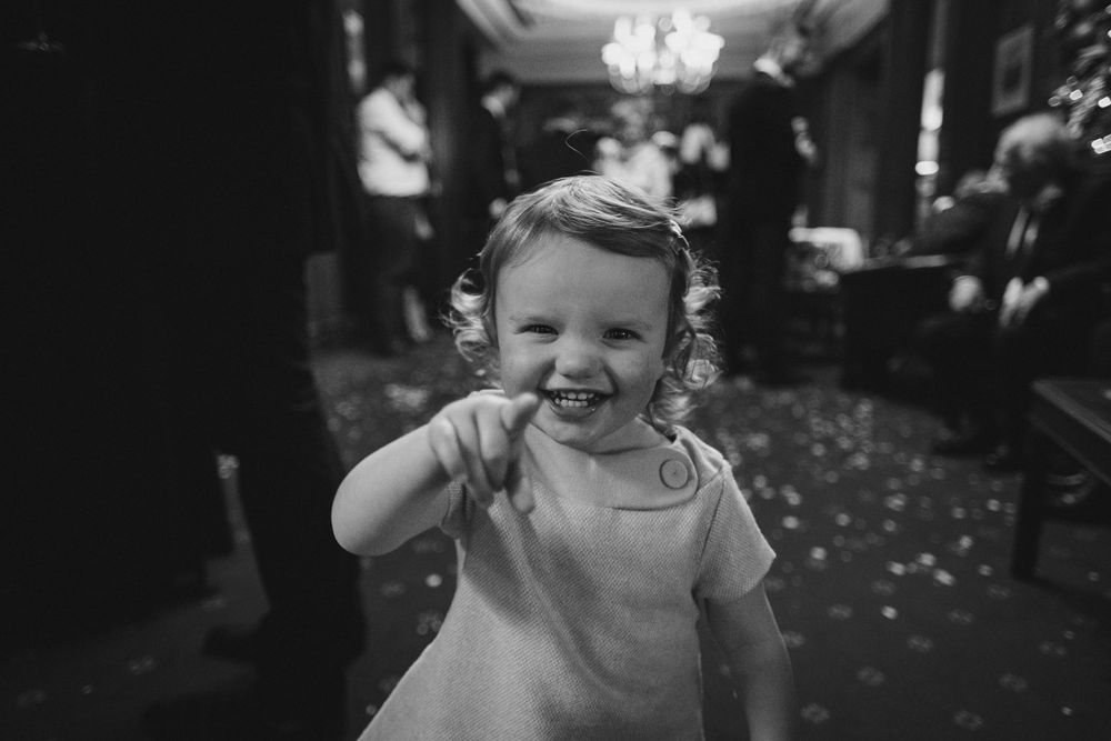 Wedding reception candid moments showing guests celebrating in a chandelier-lit venue.