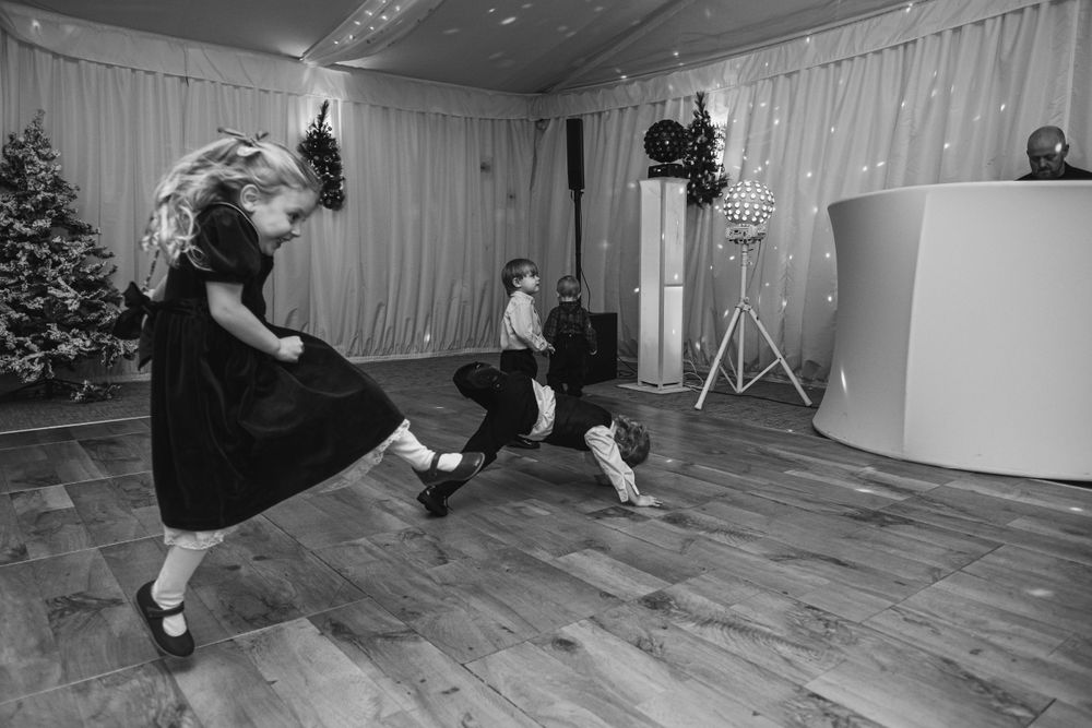 Black and white photos show people dancing energetically on a wooden dance floor at a wedding reception.