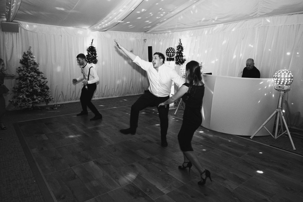 Black and white shots capture lively dance moves on a wooden floor at an indoor event space.