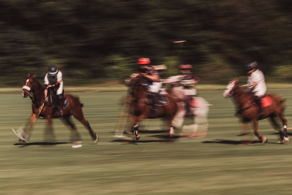 Motion blur action shot of polo players during intense match play.