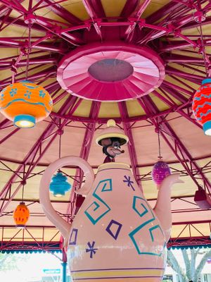 Pink circular ceiling design with decorative tribal patterns and colorful hanging ornaments in a carousel-style structure.