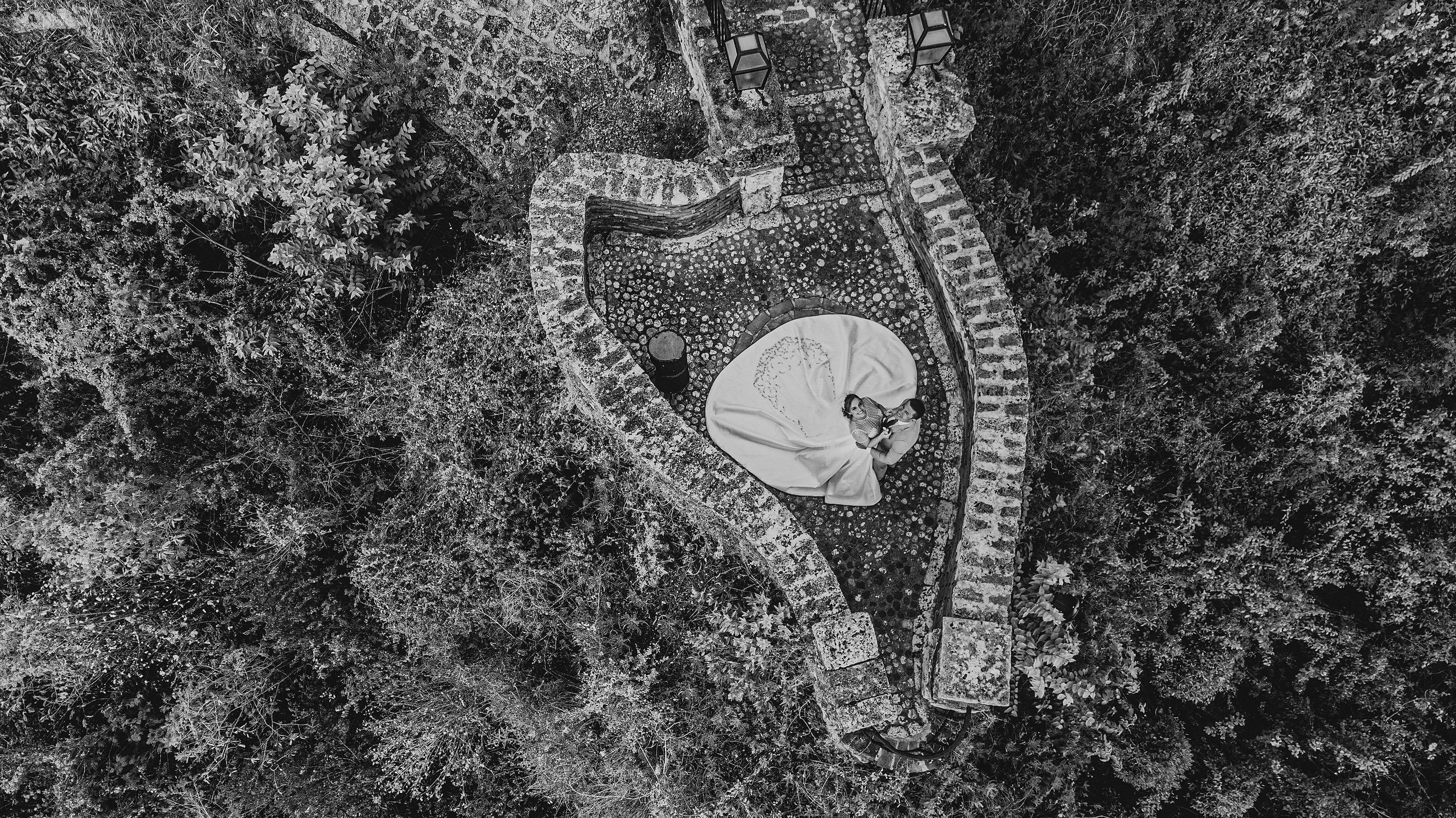 An aerial view of a heart-shaped wedding ceremony setup surrounded by lush forest.