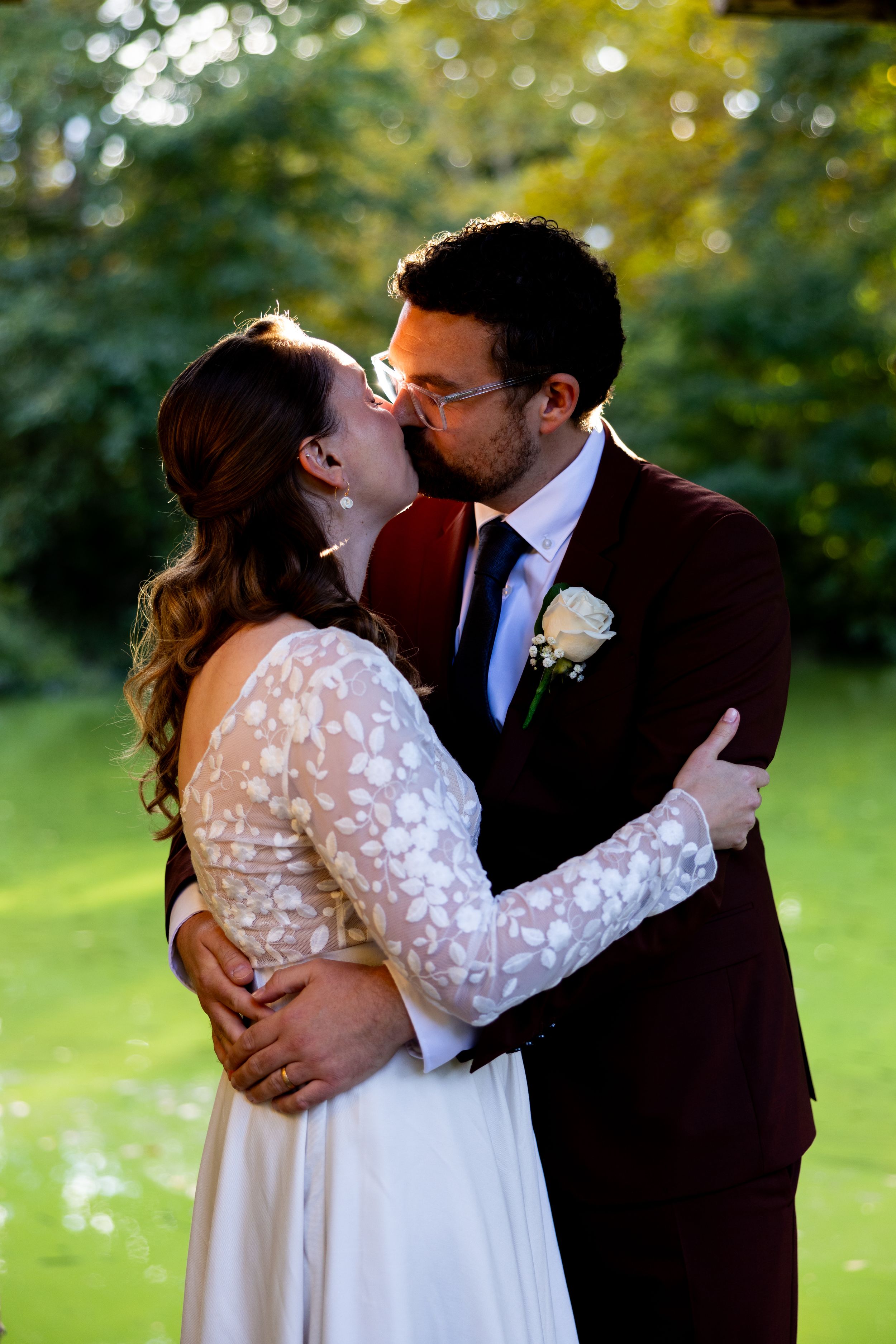 An intimate wedding moment captured in a garden setting during golden hour.