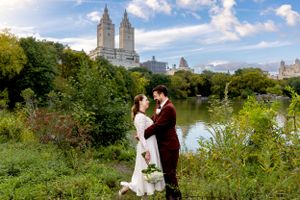 A romantic wedding photo in Central Park with the iconic San Remo building in the background.