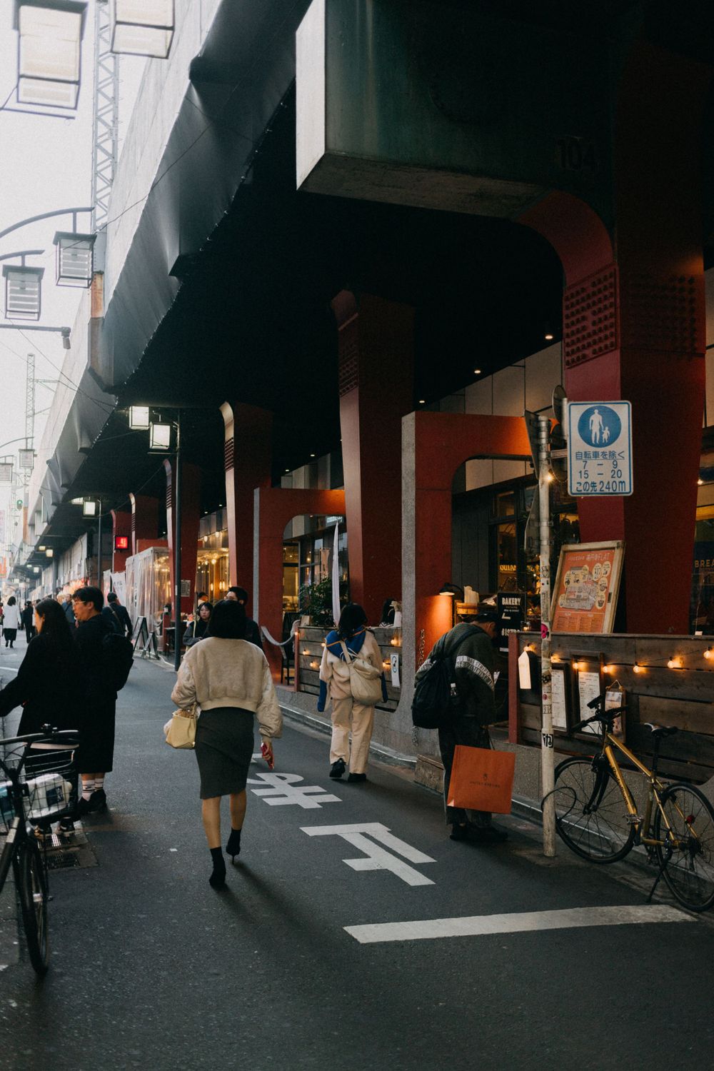 Covered walkway in Japan with pedestrians and shops along the street.