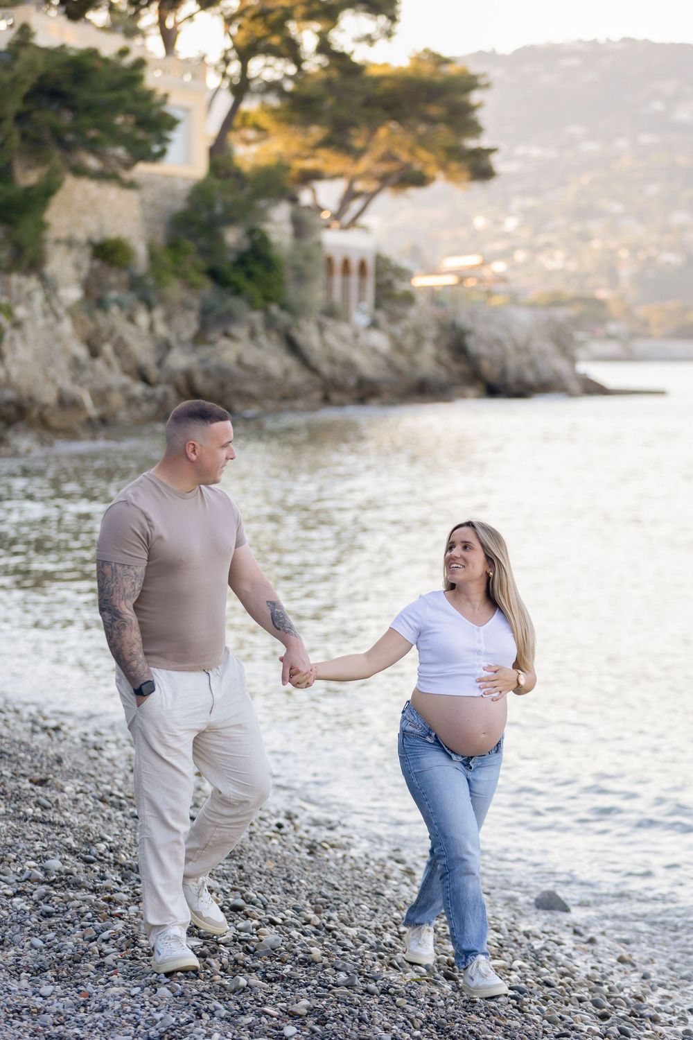 Deux personnes marchent côte à côte au bord de plage de St Jean Cap Ferra lors d'une séance photo grossesse romantique