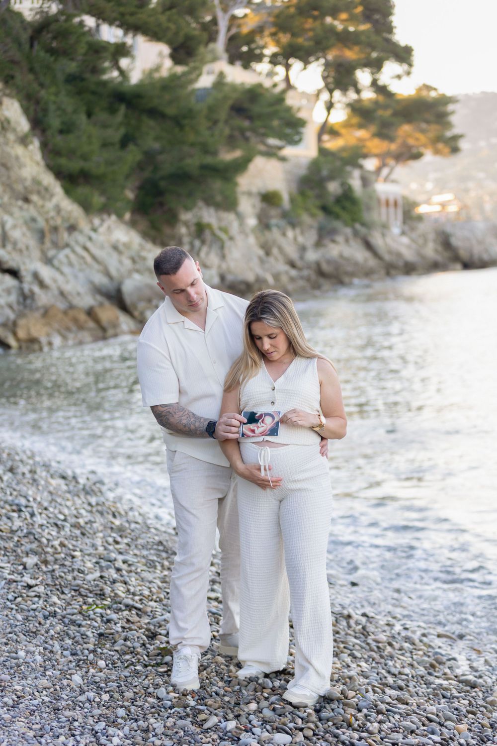 La femme enceinte et son partenaire regardent ensemble une photo d'échographie qu'ils tiennent délicatement