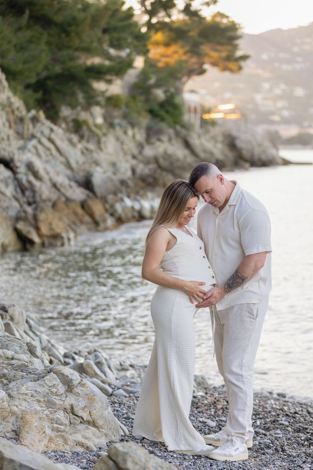 Le partenaire entoure délicatement la femme enceinte et pose ses mains sur son ventre avec tendresse