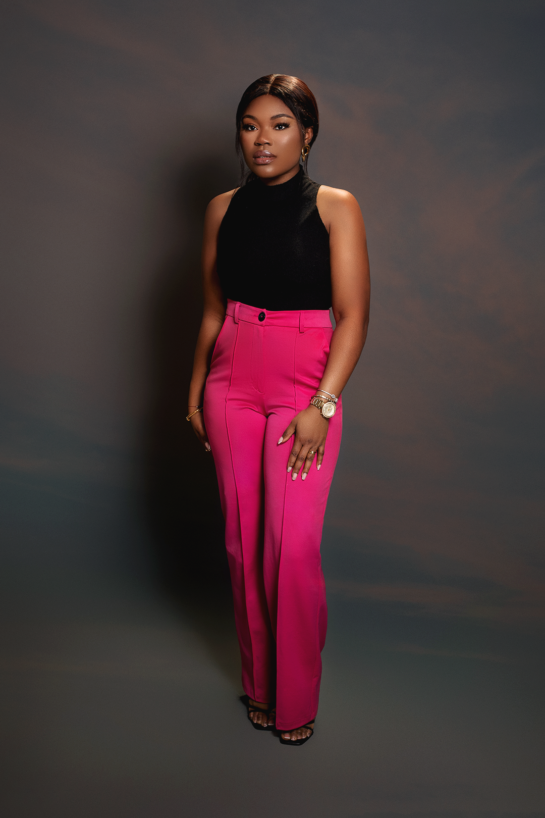 A stylish portrait in a black sleeveless top and hot pink wide-leg pants.