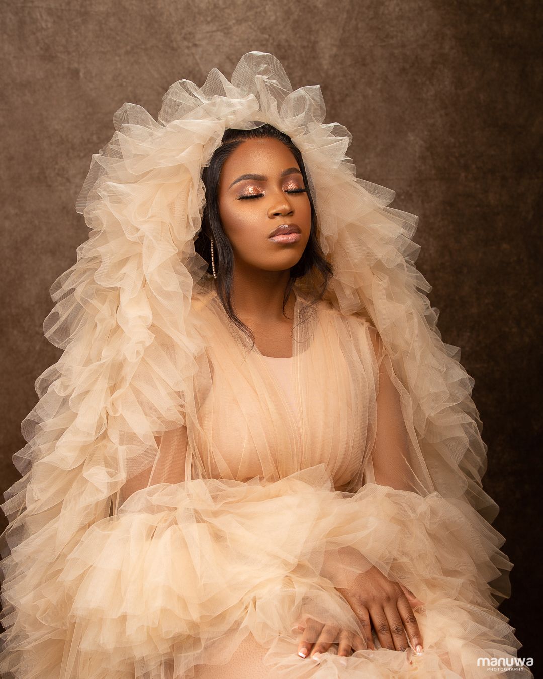 Dreamy portrait in flowing peach tulle gown with dramatic ruffled details.