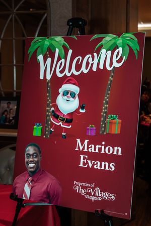 Red welcome signs with Santa Claus illustrations and palm trees displayed at The Villages.
