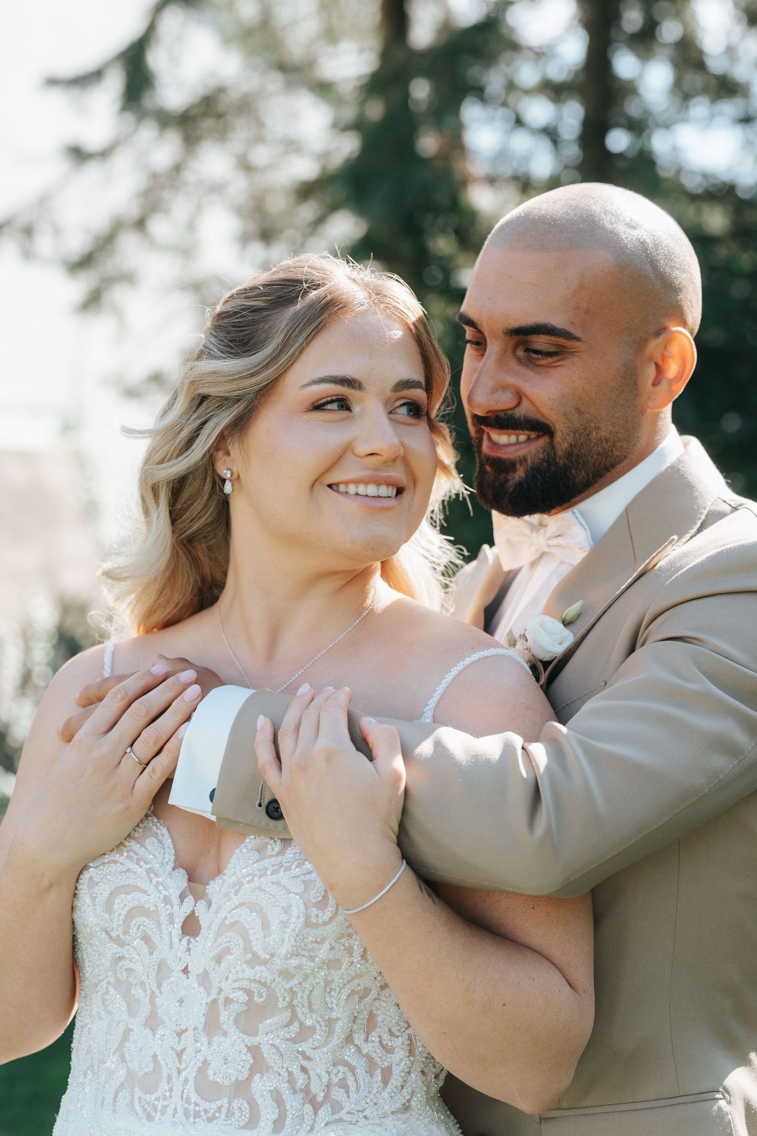 A romantic wedding photo series showing tender moments between a couple in formal attire against a sunlit outdoor setting.