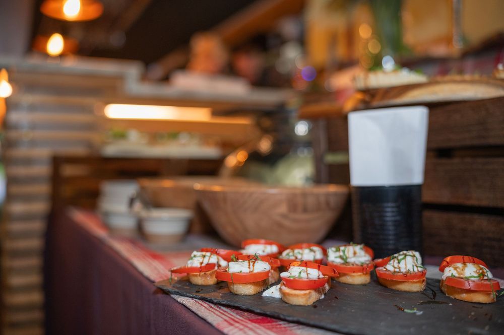 Catered appetizers and hors d'oeuvres displayed on rustic wooden serving platters.