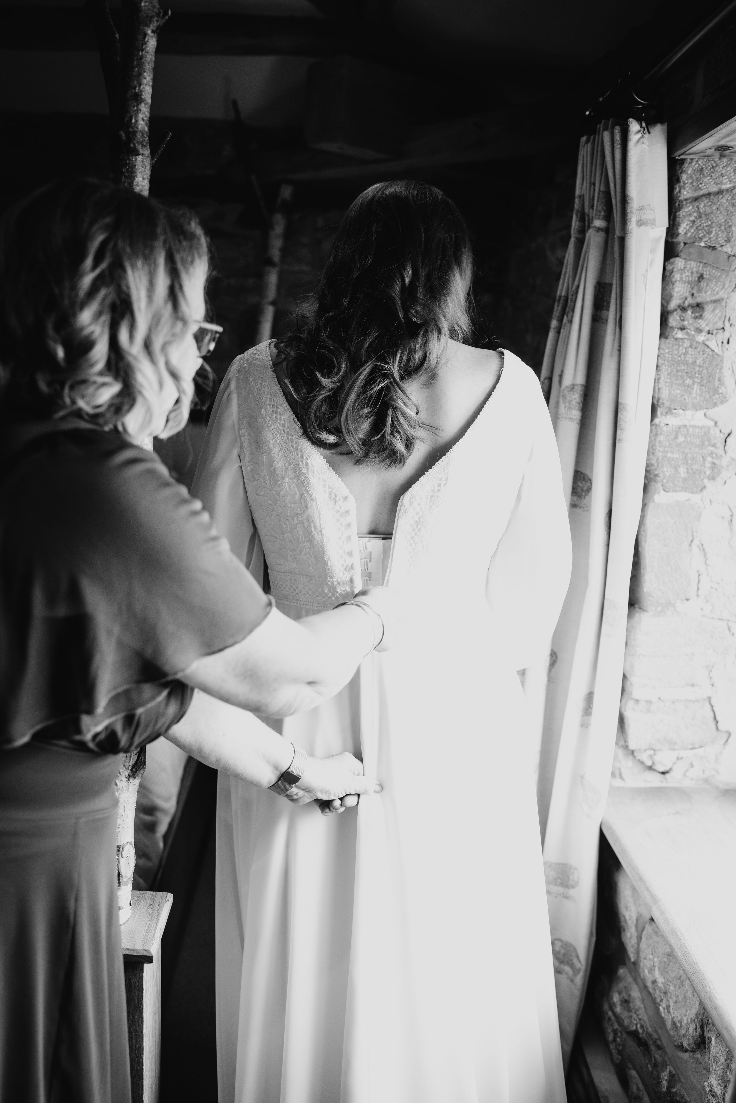 Black and white artistic photographs showing the back of a wedding dress in multiple angles.