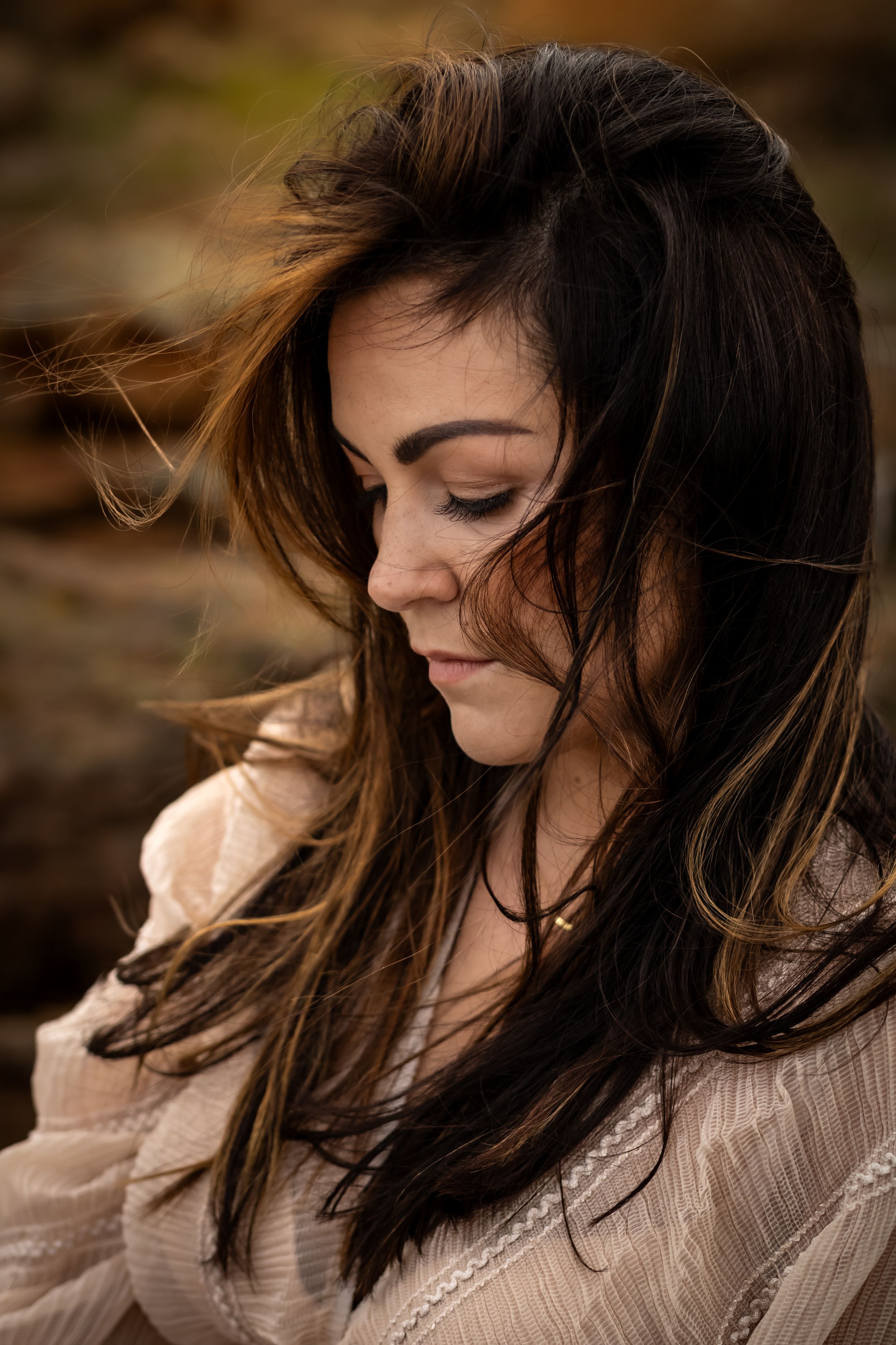 Close-up shot of windswept dark hair against natural background.