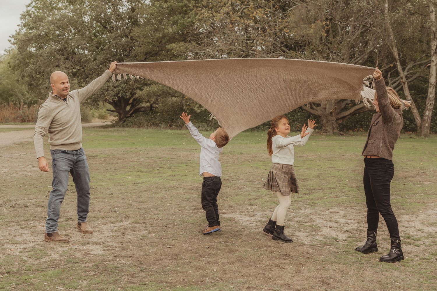 A group of people playing frisbee together in a park on a sunny day.