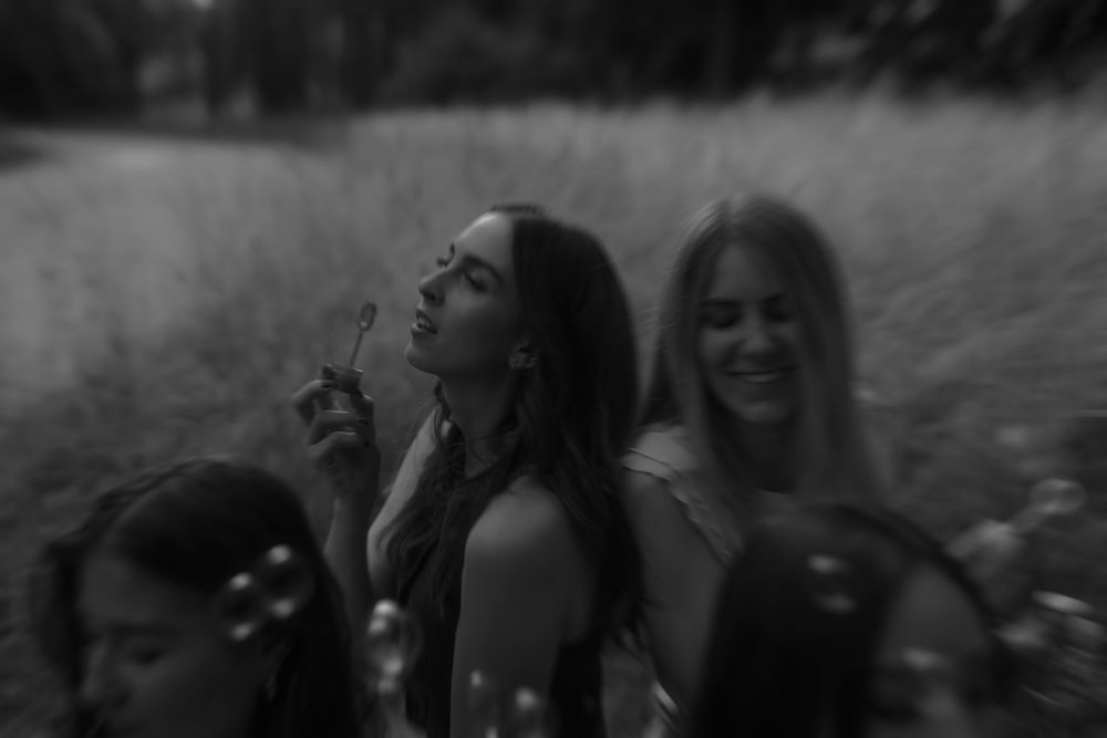 Black and white portrait of joyful friends laughing together outdoors.