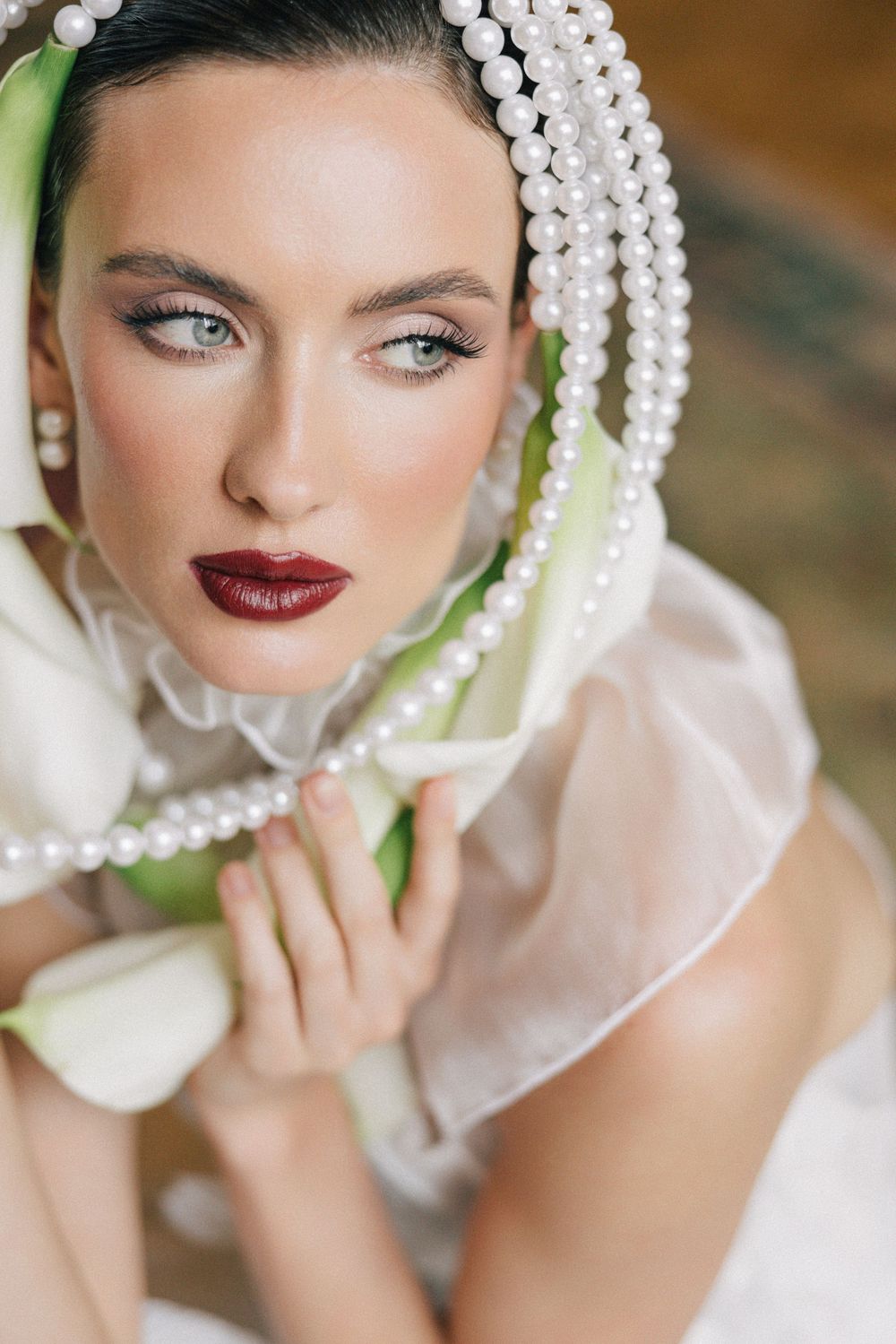 Romantic bridal portrait with pearl accessories and dramatic makeup.