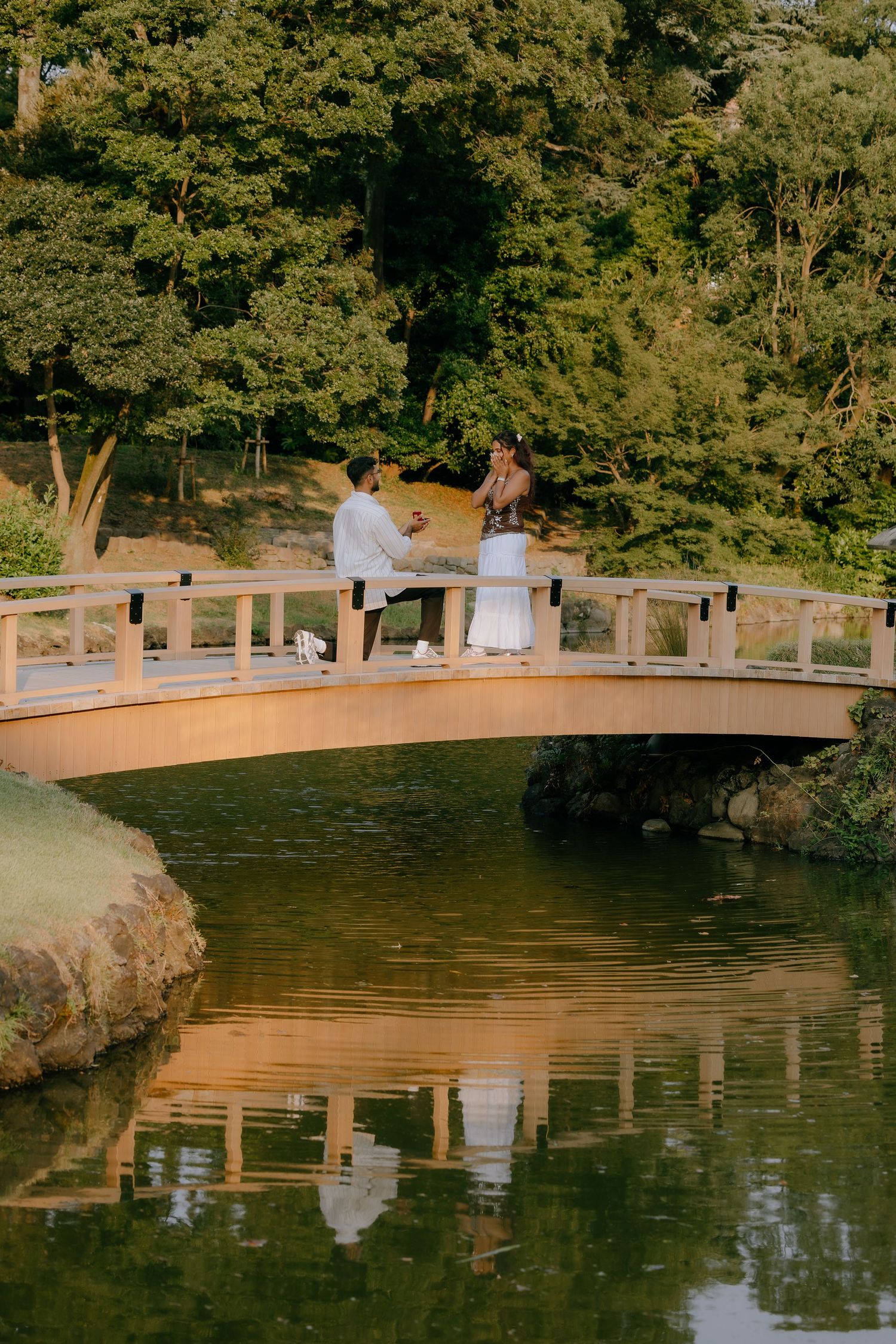 Surprise proposal at wooden bridge of Japanese garden at Shinjuku Gyoen National Garden