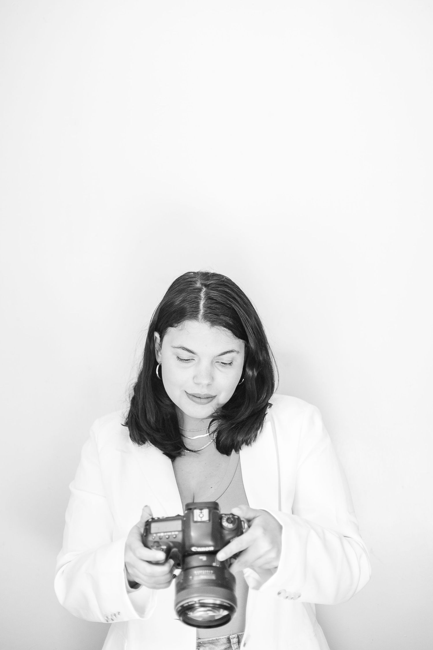 black and white photos showing a photographer holding and examining a 5d mark iv camera in different positions.