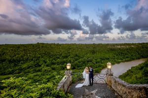 Aerial view of a scenic coastal landscape with lush green vegetation and dramatic cloudy skies.