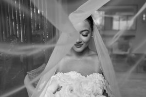 A series of black and white wedding photos showing a bride in a lace dress with veil in different poses.