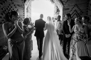 Wedding guests dance together during a reception celebration in black and white photography.