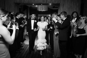 Wedding guests dance and celebrate on a dance floor during an evening reception.