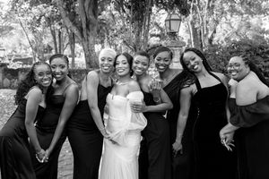 A series of black and white wedding photos showing joyful group poses and candid moments during a celebration.