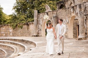 Couple walking along stone pathway surrounded by historic architecture.